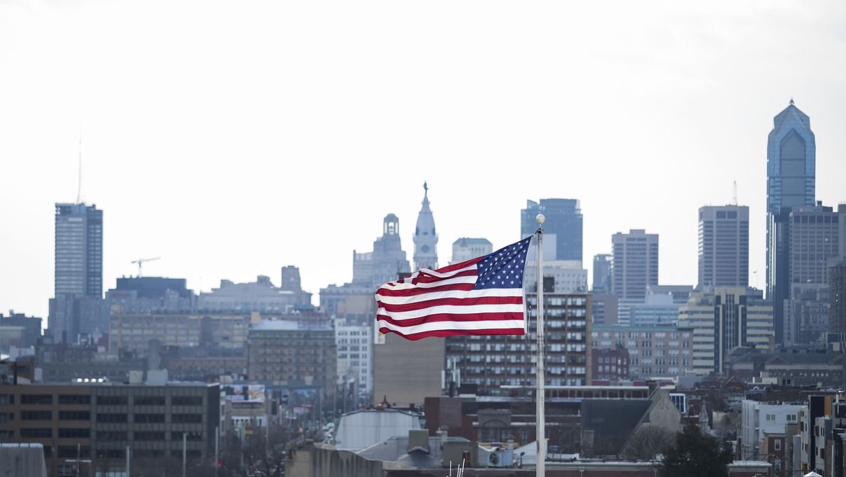 The U.S. flag flying against the Philadelphia skyline.