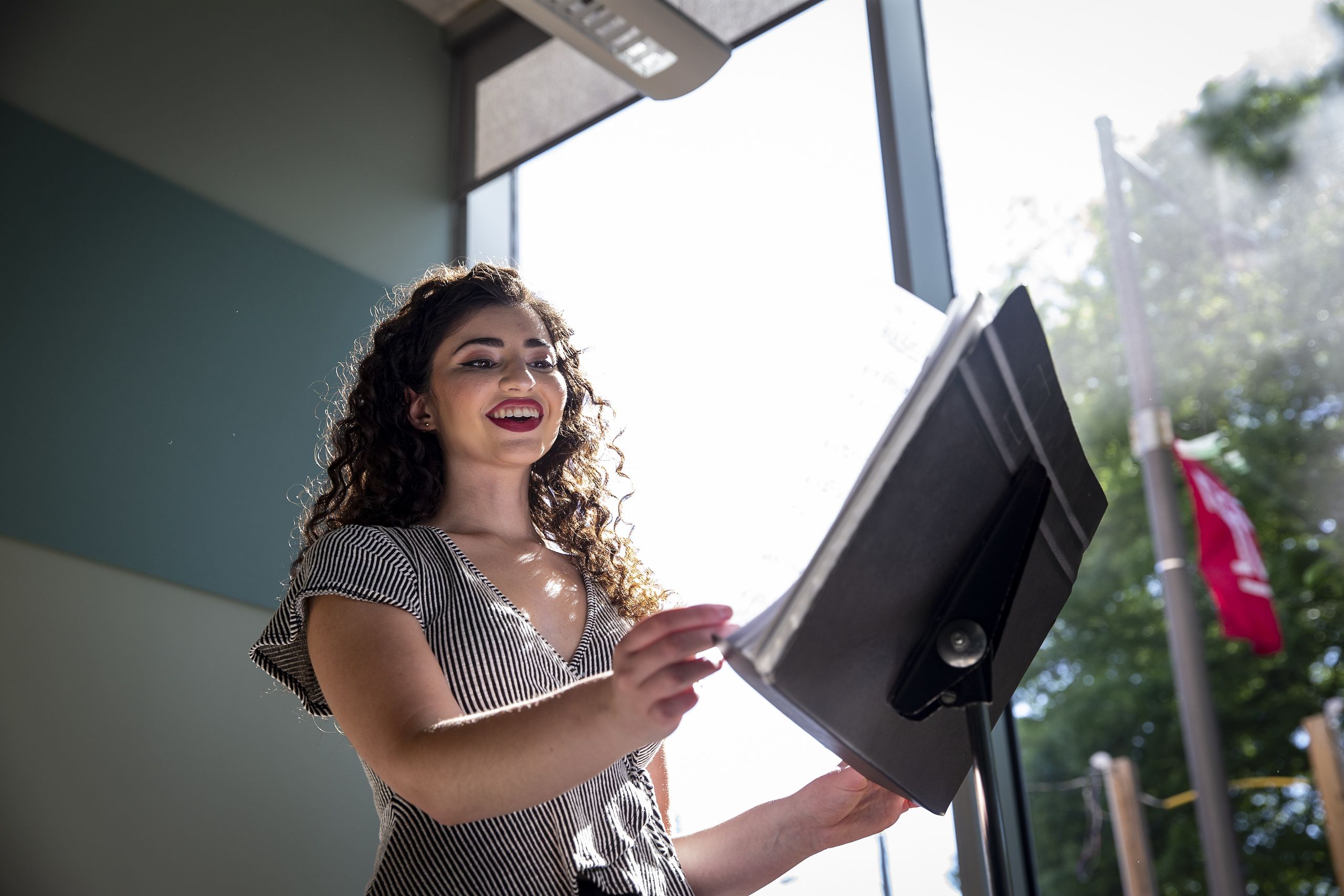 Abigayle Stoetzer singing with a music stand in front of her. 