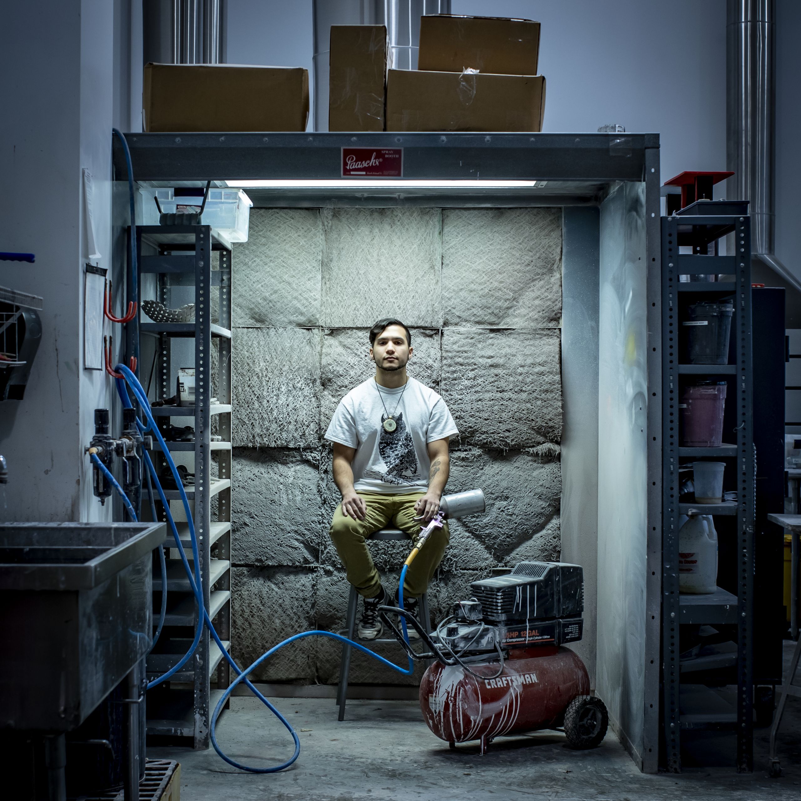 Anthony Romero sitting among art supplies and tools. 