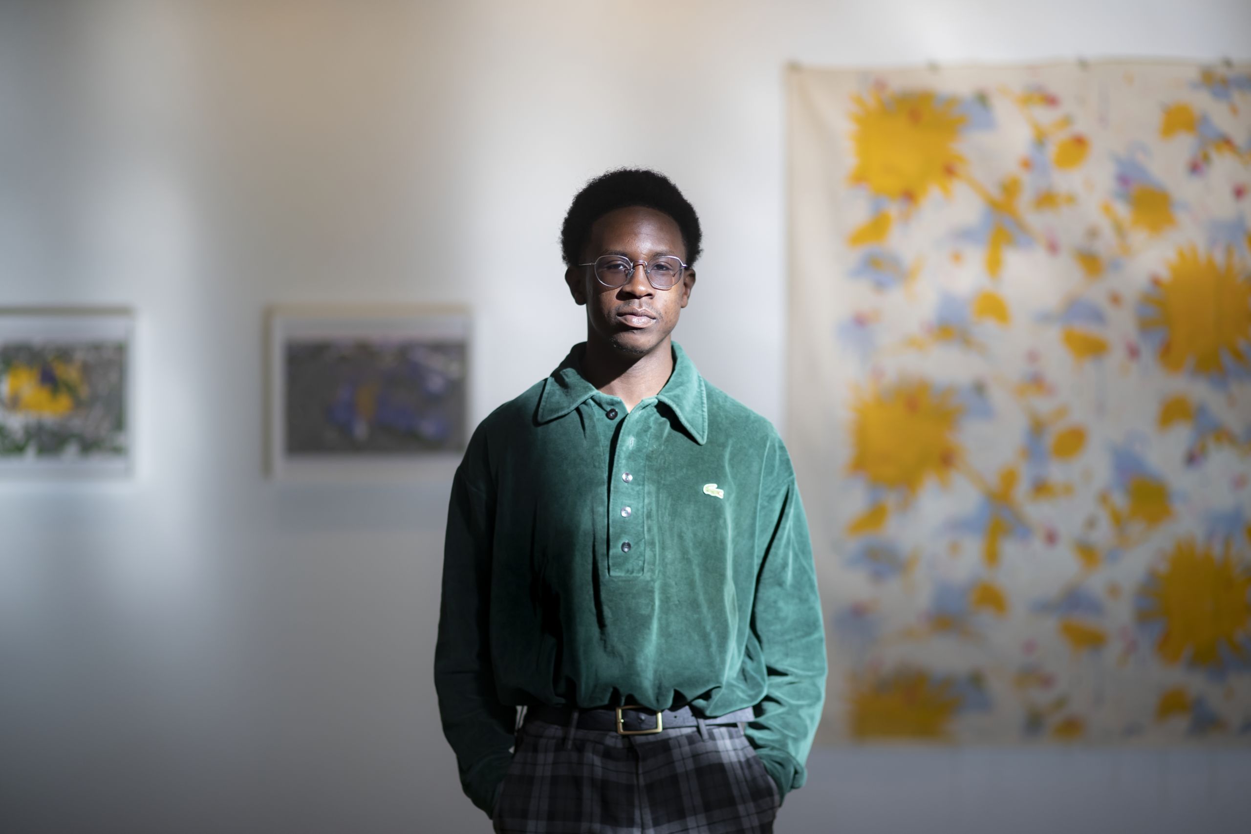 Lloyd-Princeton Cangé standing in an art gallery. 