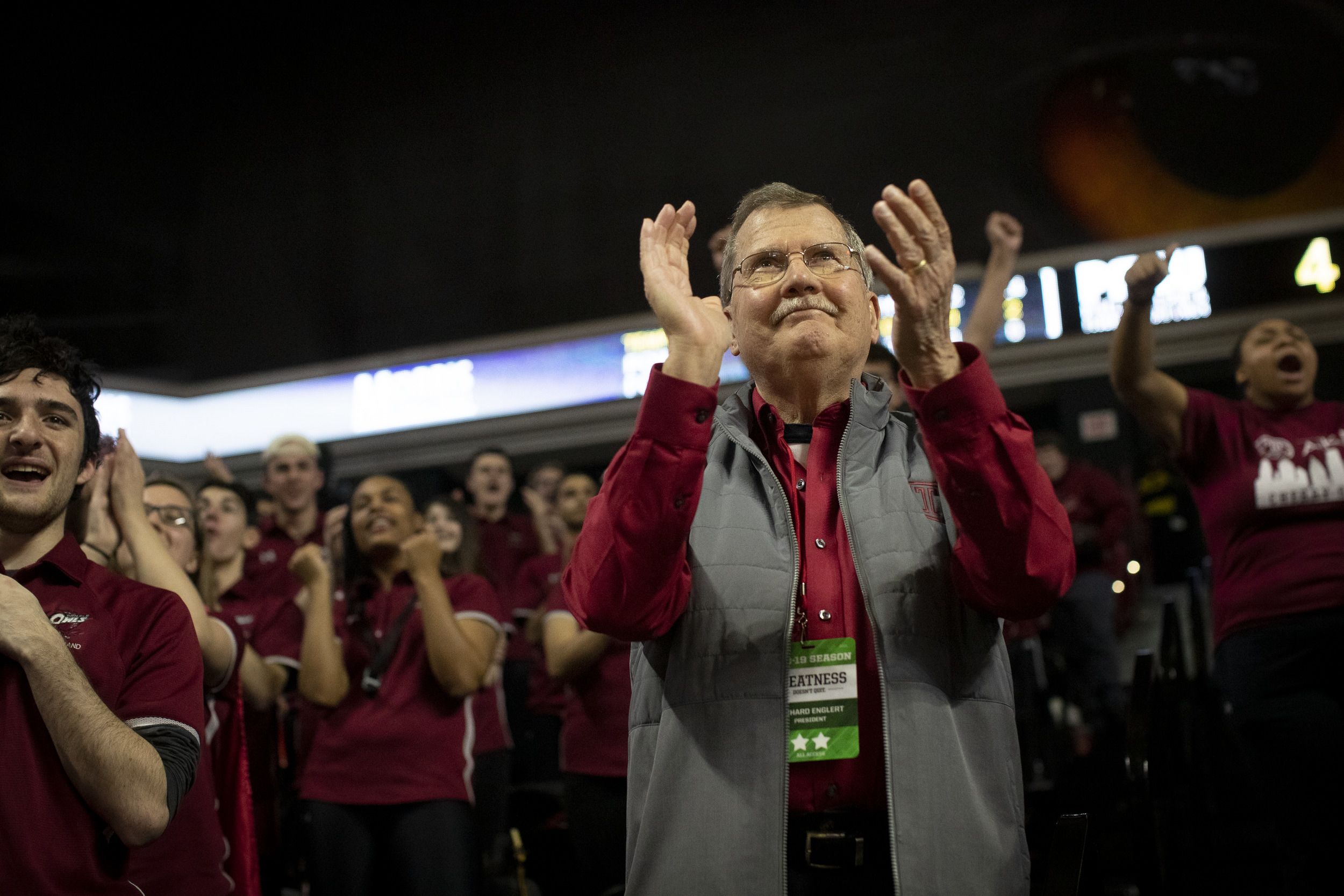 President Englert in the stands at a Temple basketball game, clapping.