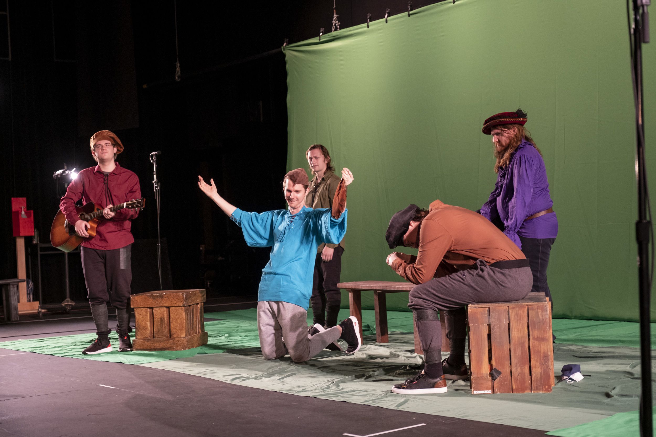 5 actors on stage, in front of a green screen.